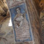 Detail view of fresco depicting figures underneath arch